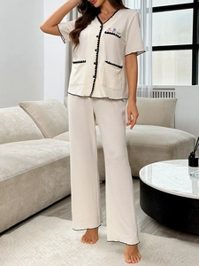 Détail du pyjama en seersucker avec broderie tulipe et bordures ondulées noires contrastées