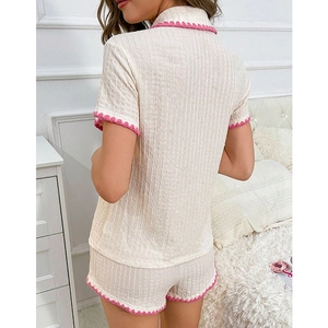 Détail du haut de pyjama beige gaufré avec bordure festonnée rose contrastée fine
