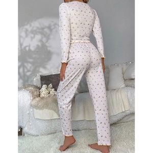 Floral pajama set back view showing ruffled cuffs and hem in a cozy home setting