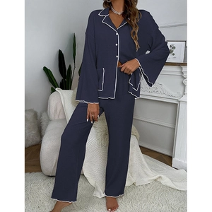Detail view of navy blue pajama set with white piping, lapel collar and side pockets