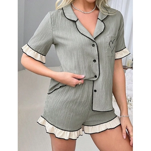 Sage green short-sleeve pajama set with embroidered heart pocket and ruffle trim