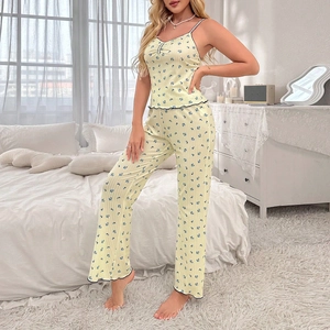 Détail du haut à fleurs à fines bretelles et pantalon avec bords volantés noirs
