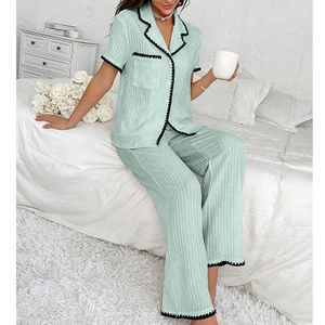 Detail of light green pajama set with lapel collar and decorative black wavy lace edges