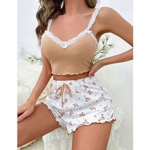 Détail de la dentelle sur le caraco beige côtelé et du short de pyjama à fleurs