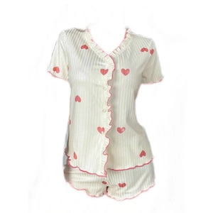 Women's two-piece heart print pajama set with short sleeves, shorts, and ruffle trim