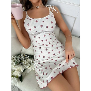 Dettaglio camicia da notte con pizzo bianco e motivo rose rosa su tessuto a costine