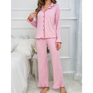 Pink women's long sleeve pajama set with red contrast piping and ruffle trim details