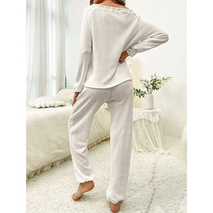 Elegant white knitted pajama set featuring long-sleeved round neck top and loose trousers