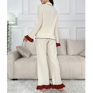 Women's cream loungewear set with red frill trim, featuring long sleeve top and pants