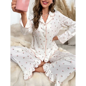 Women's pink rose floral satin pajama set with long sleeves and ruffled hem on white rug