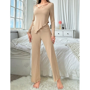 Detail of beige ribbed knit lounge set featuring asymmetric hem and lettuce edge trim
