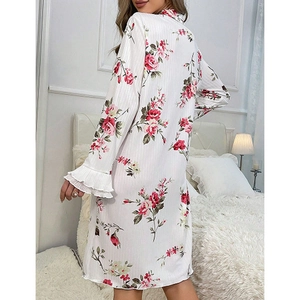 Floral white long sleeve nightgown with ruffled cuffs shown in a cozy bedroom setting