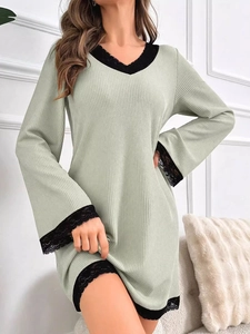 Detail of light green ribbed knit nightdress featuring black lace trim on sleeve and hem