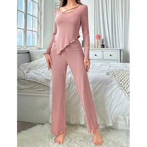 Detail of pink ribbed pajamas featuring a V-neck wrap top and wavy hemline texture
