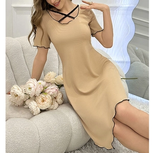 Detail of khaki knit dress featuring black ruffled edges and delicate lace-up neckline