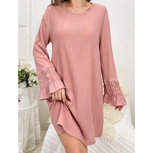 Detailed close-up of pink round neck nightgown with textured fabric and ruffled sleeve cuffs
