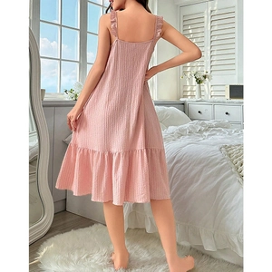 Close-up of pink waffle texture fabric with ruffle hem and strap details on a nightdress
