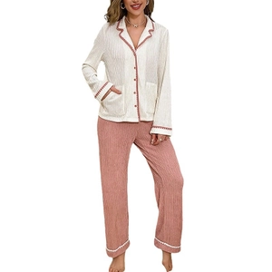 Women's two-piece pajamas set featuring white lapel top and pink pants with ribbed texture