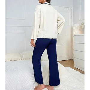 Chic two-piece women's pajama set featuring a textured cream cardigan and navy wide-leg pants