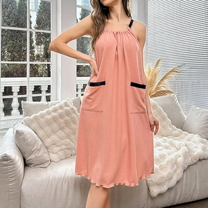 Détail d'une robe de chambre pêche sans manches avec texture plissée et poches latérales