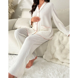 Close-up of cream knit pajama set with pink piping and ribbed texture detail
