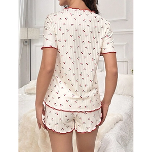 Detail of cherry print pajama set showing red lettuce trim and ribbed texture
