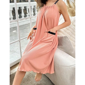 Détail de la robe rose à fines bretelles avec encolure froncée et poches bordées