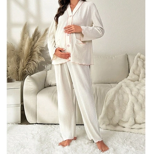 Cream white ribbed maternity pajama set with pink piping and buttons in home setting