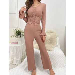 Dettaglio del top con scollo a V e coulisse e maniche svasate nel pigiama rosa