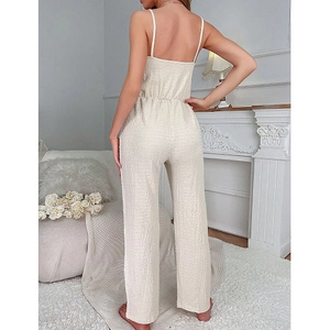 Champagne backless pleated wide-leg jumpsuit with thin straps shown in an elegant room