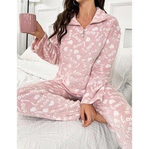 Pink fleece pajama set for women with white heart and love patterns in a home setting