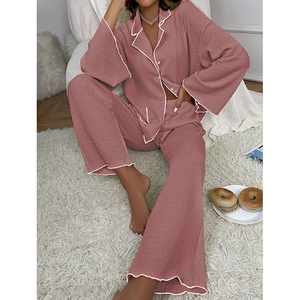 Détail d'un pyjama plissé mauve avec liserés blancs et texture plissée verticale