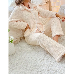 Détail d'un pyjama doux à col poupée avec bordures en dentelle en polaire crème douce