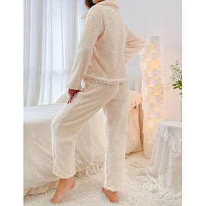 Détail du pyjama en peluche crème montrant le molleton doux et la bordure en dentelle