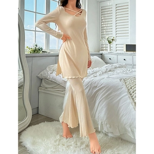 Elegant beige two-piece knit lounge set with cross-strap top and flared pants for women