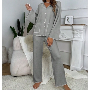 Détail du pyjama gris en maille gaufrée avec liseré blanc et poches carrées à l'avant