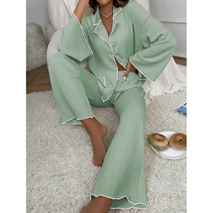 Détails d'un ensemble pyjama vert sauge en maille gaufrée avec liseré contrasté et boutons