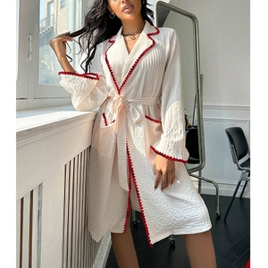 Peignoir blanc élégant avec bordure ondulée rouge et manches longues pour la détente