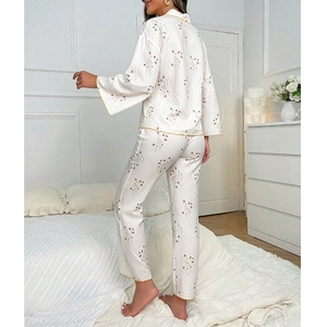 Floral print long sleeve pajamas set with yellow piping for women shown in a cozy bedroom