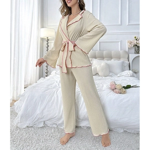 Detail of waffle textured pajama fabric with pink ruffled trim and tie waist closure