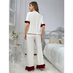 Women's cream knit pajama set with red ruffled hem and wide-leg lounge trousers