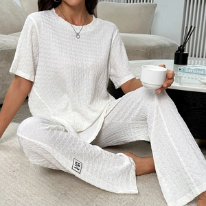 Ensemble homewear blanc pour femme avec haut à col rond et pantalon à texture gaufrée