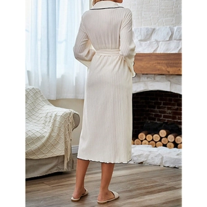 Detail of cream rib-knit bathrobe fabric with black contrast piping and waist tie on the back