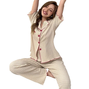 Women's apricot button-down pajama set with short sleeves, long pants and pink piping