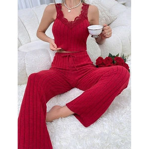 Detail of red knit pajama set with V-neck lace trim and ribbed texture on the camisole
