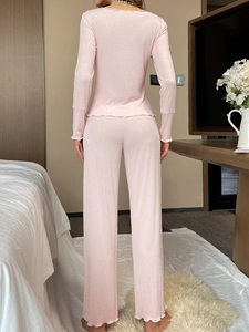 Vue détaillée du pyjama côtelé rose avec finitions volantées et pantalon large fluide