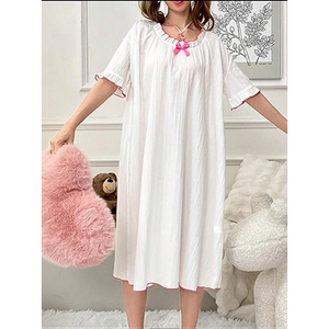 Détail de chemise de nuit blanche avec nœud rose et manches à volants élégantes