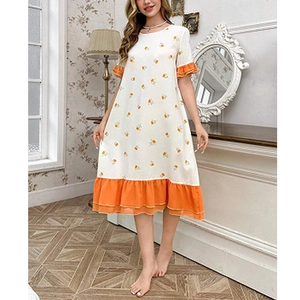 Détail de la robe de nuit à fleurs oranges avec ourlet à volants et tissu blanc doux