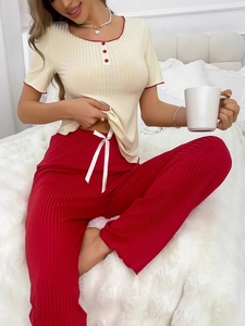 Détail d'un haut à manches courtes et d'un pantalon rouge en tissu côtelé avec nœud