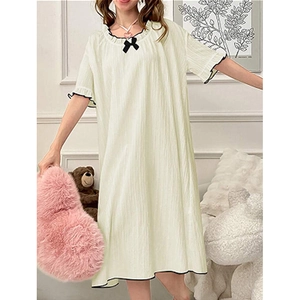 Détail de la chemise de nuit crème avec noeud noir et tissu seersucker gaufré